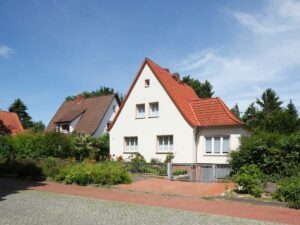 Einfamilienhaus mit rotem Pultdach und weiß gestrichen.
